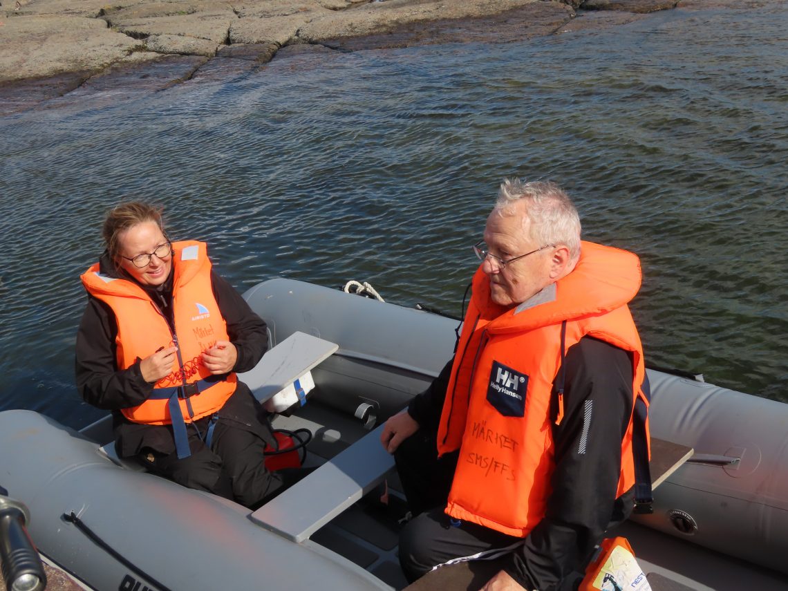 Mies ja nainen veneessä pelastusliivit päällä