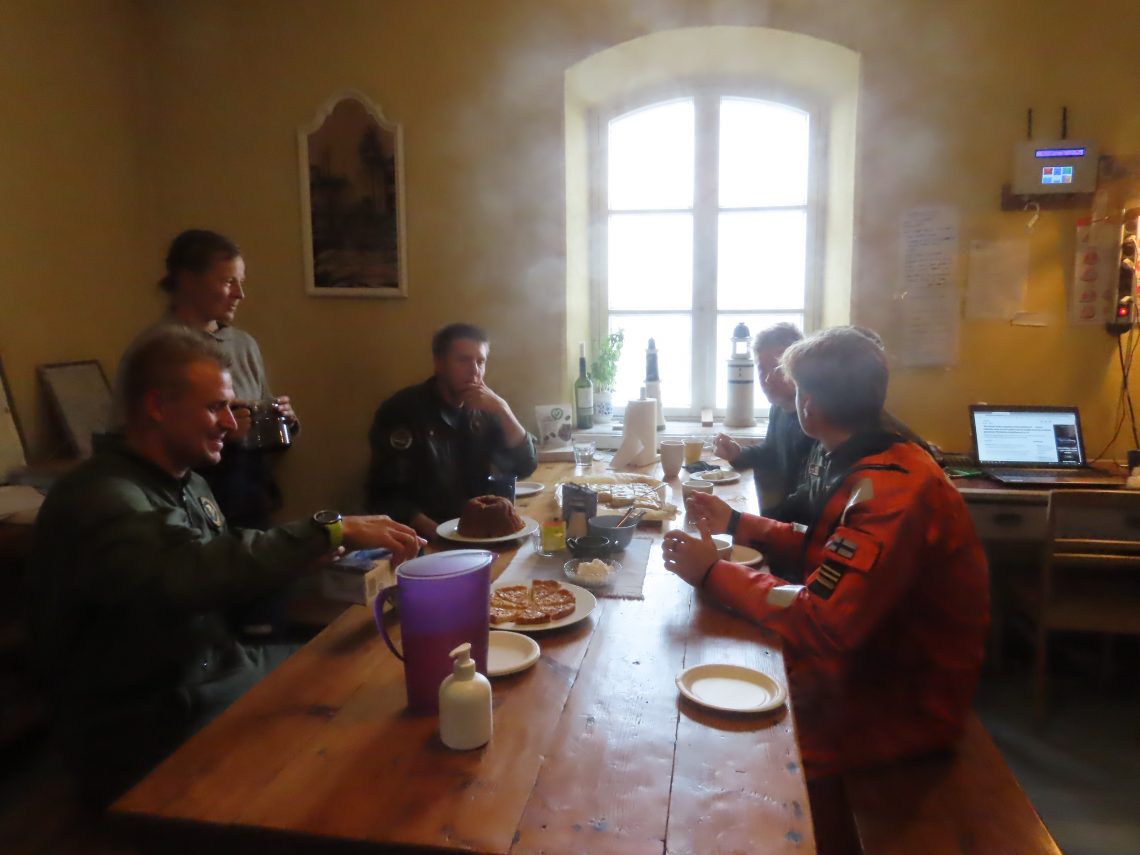 Super Puma-helikopterin henkilökunta istuu kahvipöydässä Märketin majakalla