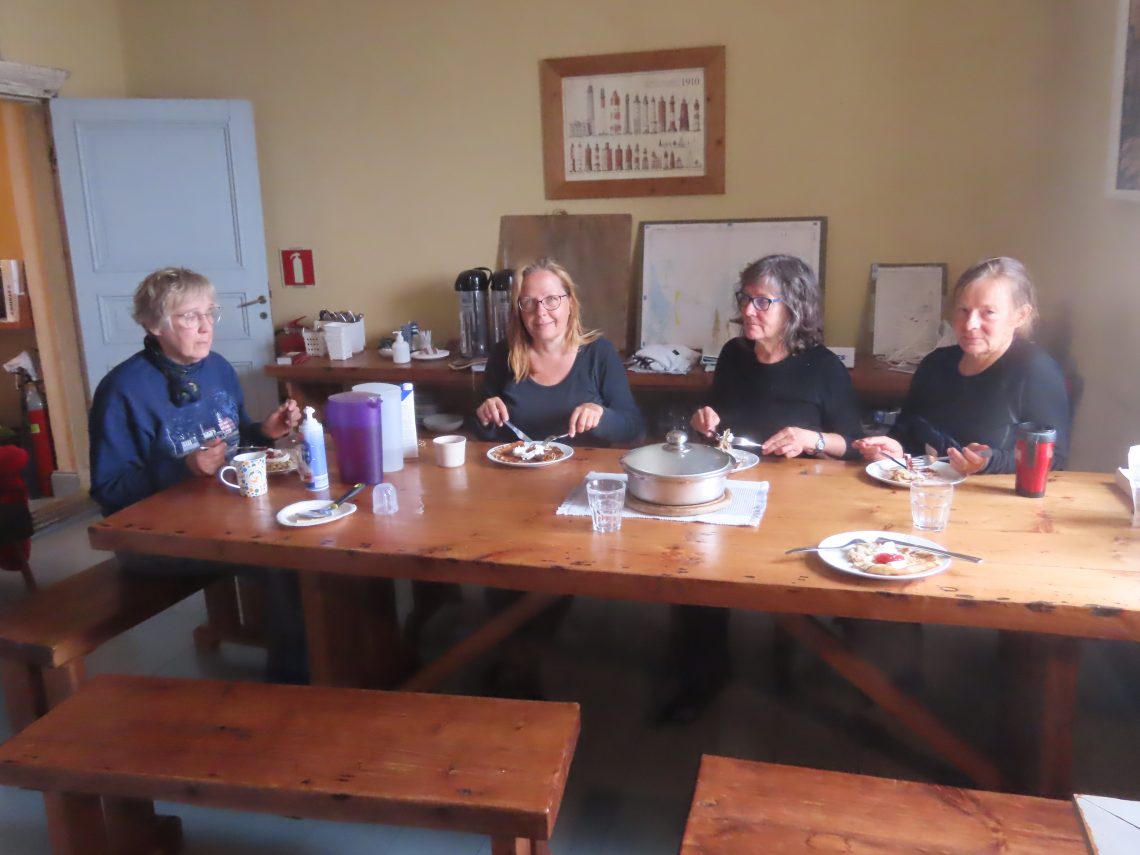 Neljä naista istuu pöydän ääressä syömässä lettuja