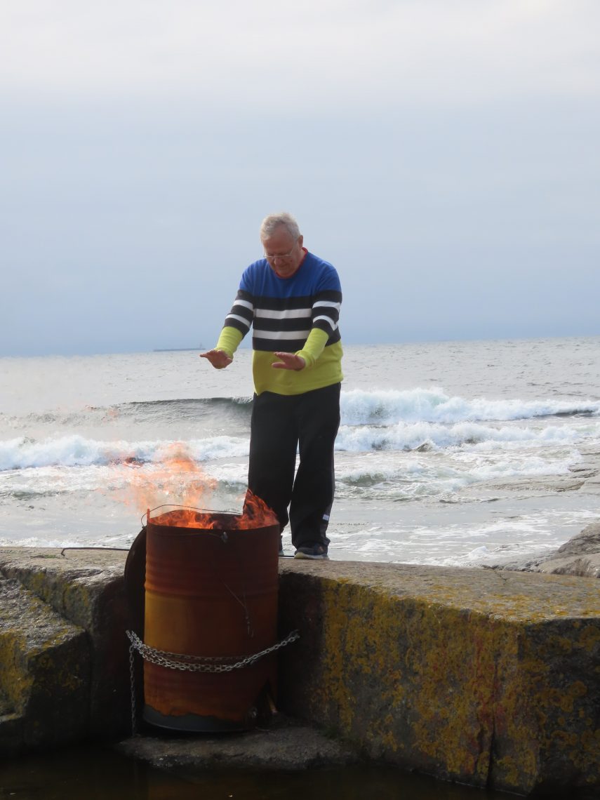 Mies polttaa roskia tynnyrissä
