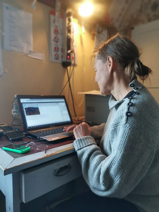 Nainen istuu tietokoneen edessä