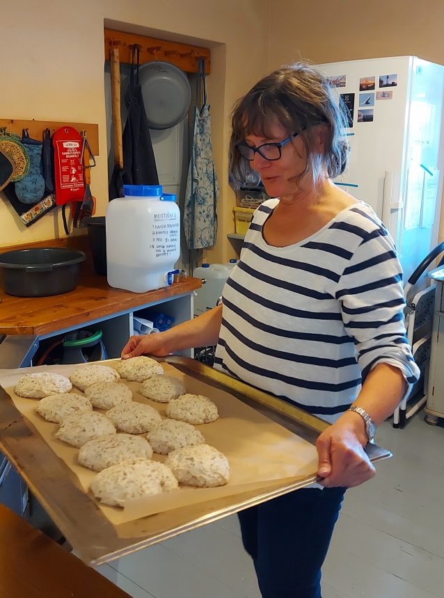 Nainen leipoo sämpylöitä