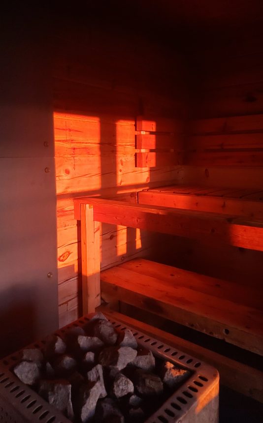 Laskeva aurinko valaisee saunan